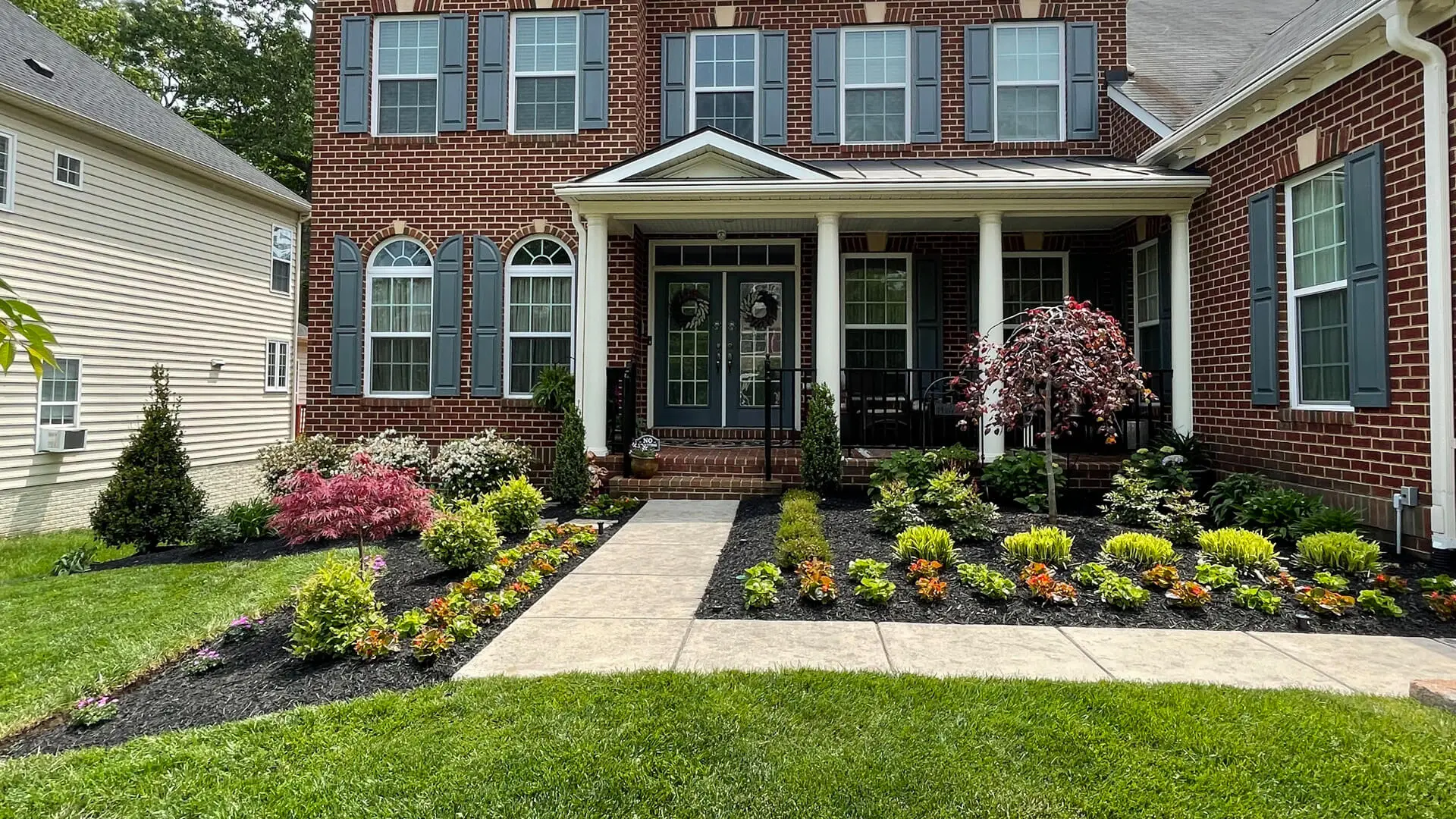 Landscape beds with colorful plants in front of a home in Bristow, VA.