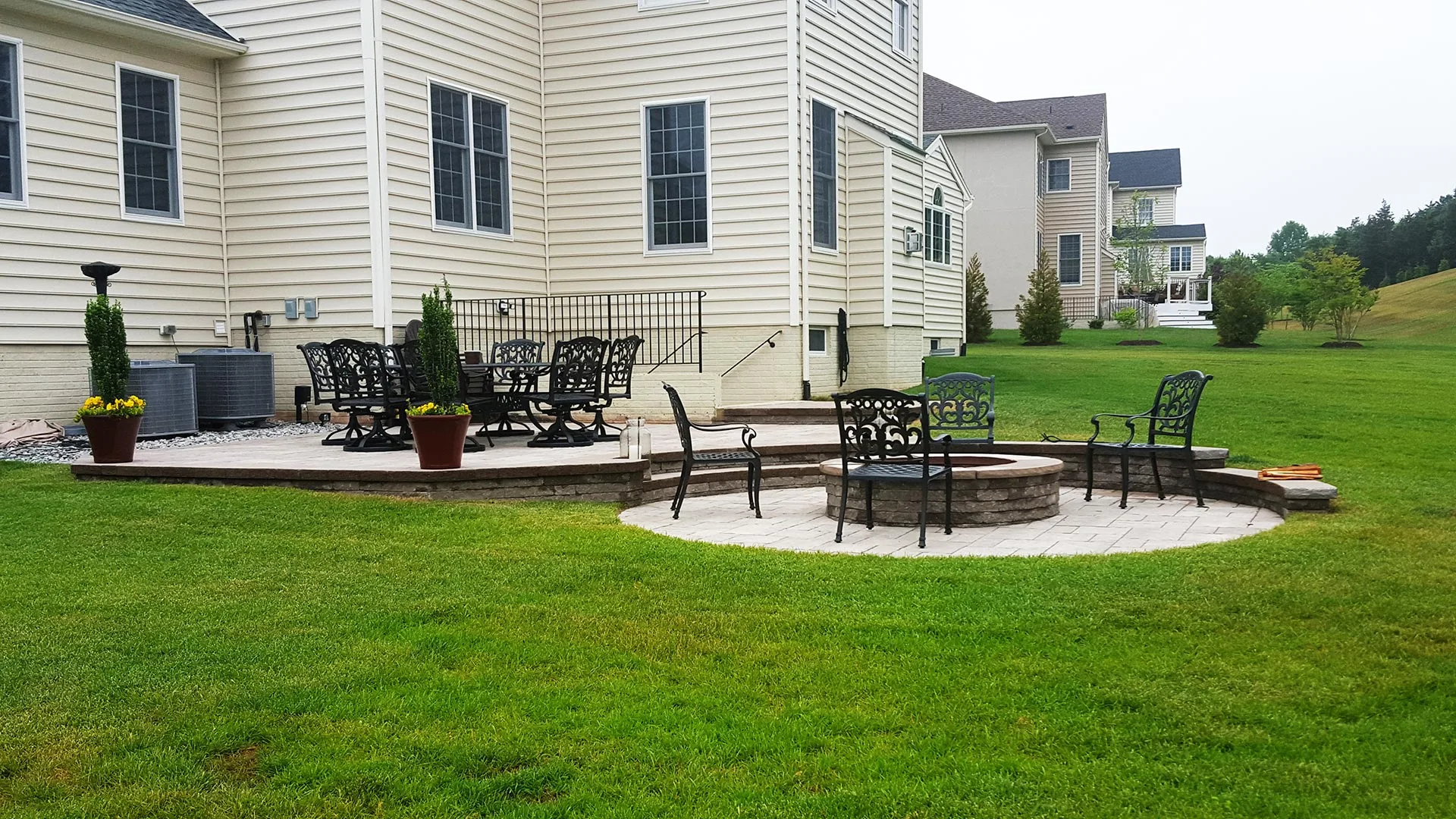 New Baltimore, VA home property with healthy lawn and custom patio and fire pit construction.