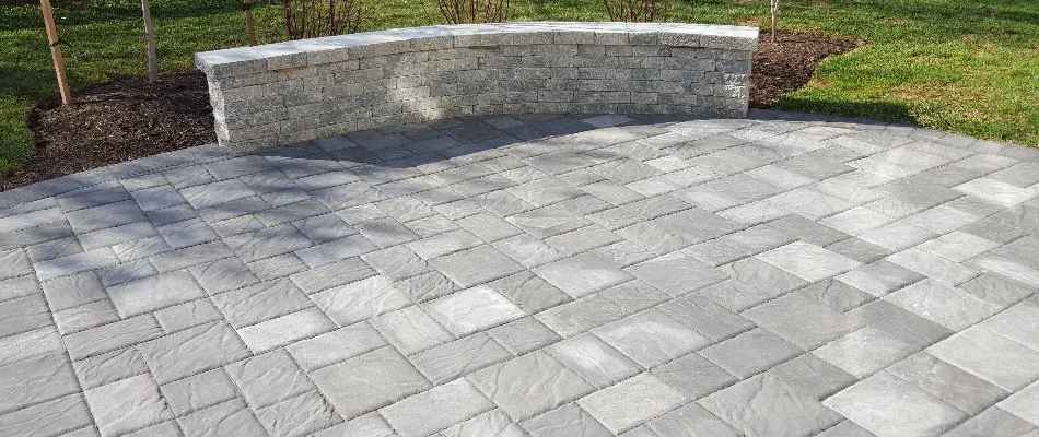 A concrete paver patio in Bristow, VA, with a seating wall.