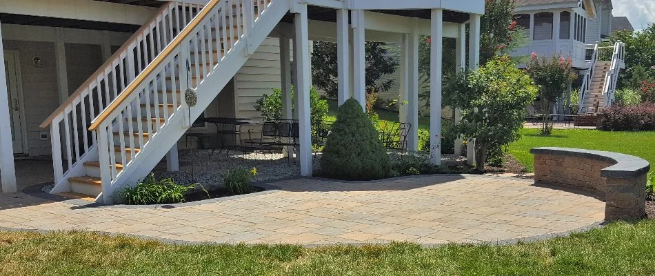 A patio with a seating wall in Bristow, VA, near a covered area and stairs.