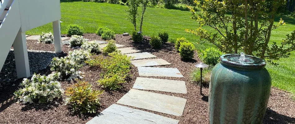 Stone steps, mulch, plants, and a water feature in a landscape in Sudley, VA.